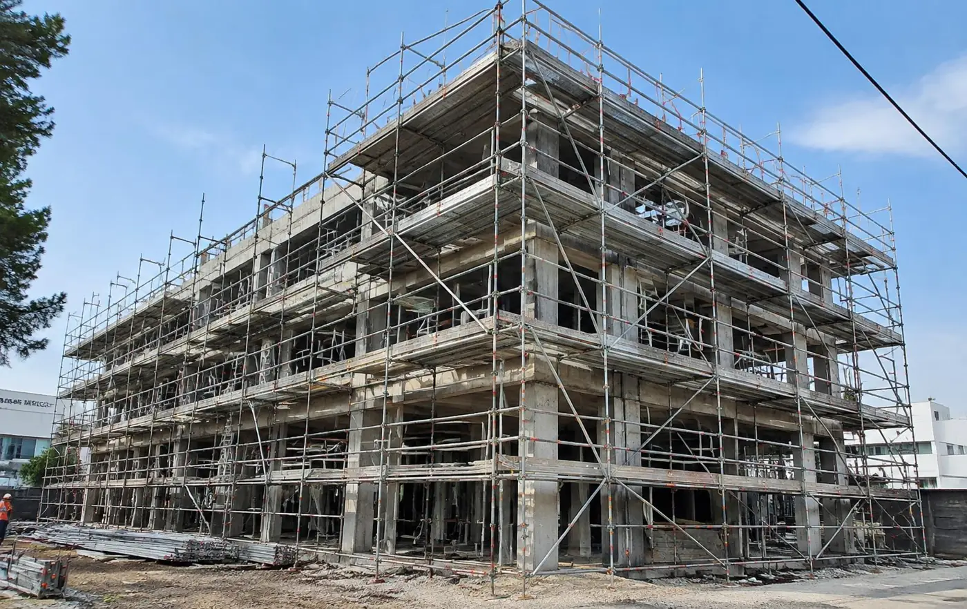 Andamio multidireccional cubriendo un edificio de tres niveles en construcción (imagen ilustrativa)